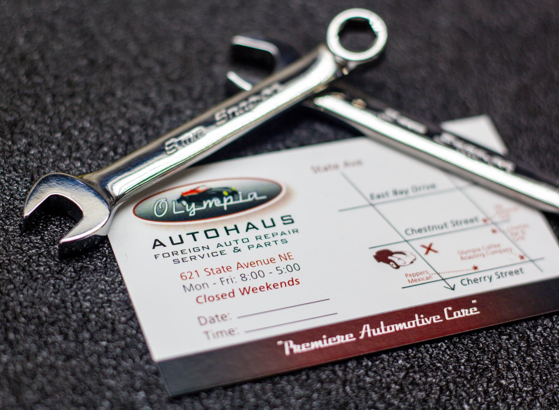 Olympia Autohaus service card with mechanic tools